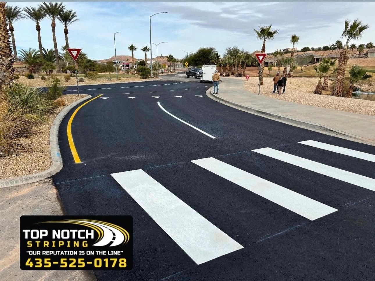 Freshly striped desert road intersection with yellow and white markings